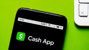 The Cash App (SQ) logo appears on an iPhone screen.