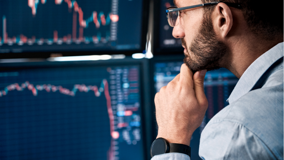 Man looking at the monitors with crypto price charts